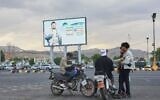 Young men gather beneath a billboard depicting Houthi leader Abdul-Malik al-Houthi in Sanaa, Yemen, September 15, 2026. (AP Photo/Osamah Abdulrahman)