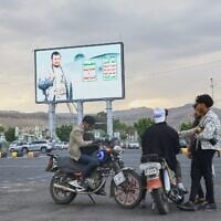 Young men gather beneath a billboard depicting Houthi leader Abdul-Malik al-Houthi in Sanaa, Yemen, September 15, 2026. (AP Photo/Osamah Abdulrahman)