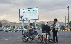Young men gather beneath a billboard depicting Houthi leader Abdul-Malik al-Houthi in Sanaa, Yemen, September 15, 2026. (AP Photo/Osamah Abdulrahman)