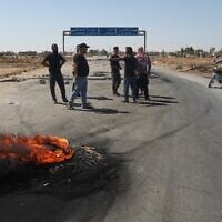 Local residents block a road to prevent oil tankers from the Rmeilan oil fields from passing during ongoing protests against higher fuel prices at the entrance to Tal Tamr, northeastern Syria, September 16, 2026. (AP Photo/Baderkhan Ahmad)