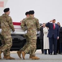 An Army carry team moves a flag-draped transfer case with the remains of Sgt. Declan Coady, 20, of West Des Moines, Iowa, past US President Donald Trump and first lady Melania Trump during a casualty return, March 7, 2026, at Dover Air Force Base, Delaware. (AP Photo/Mark Schiefelbein)