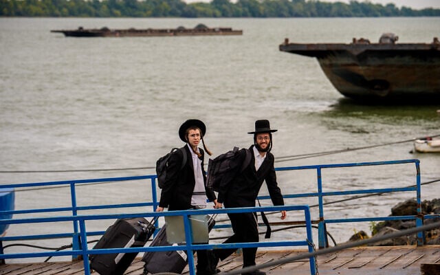 Ultra-Orthodox Jews returning from a pilgrimage in Ukraine walk off a ferry at the Isaccea Danube River border crossing in Isaccea, Romania, September 14, 2026. (AP/Vadim Ghirda)
