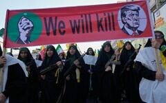 Women affiliated with Iran’s Islamic Revolutionary Guard Corps carry rifles as they march beneath a banner depicting US President Donald Trump in crosshairs and reading “We will kill” during the state-organized “Janfada,” or “Sacrifice for Iran,” military-style parade in Tehran, Iran, September 18, 2026. (AP Photo/Vahid Salemi)