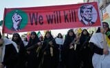 Women affiliated with Iran’s Islamic Revolutionary Guard Corps carry rifles as they march beneath a banner depicting US President Donald Trump in crosshairs and reading 'We will kill' during the state-organized 'Janfada,' or 'Sacrifice for Iran,' military-style parade in Tehran, Iran, September 18, 2026. (AP Photo/Vahid Salemi)
