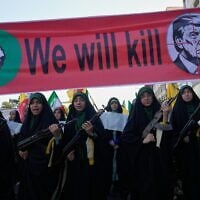 Women affiliated with Iran’s Islamic Revolutionary Guard Corps carry rifles as they march beneath a banner depicting US President Donald Trump in crosshairs and reading 'We will kill' during the state-organized 'Janfada,' or 'Sacrifice for Iran,' military-style parade in Tehran, Iran, September 18, 2026. (AP Photo/Vahid Salemi)