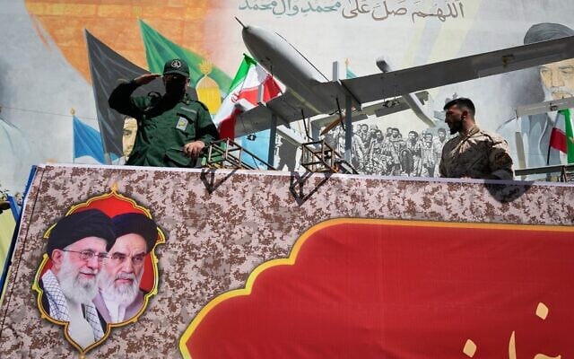 A member of Iran’s Islamic Revolutionary Guard Corps salutes while riding on a float displaying drones during the state-organized “Janfada,” or “Sacrifice for Iran,” military-style parade in Tehran, Iran, September 18, 2026. (AP Photo/Vahid Salemi)