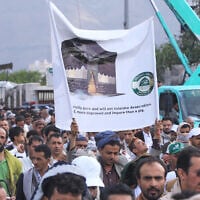 Supporters of Yemen’s Houthi rebels raise a banner during a rally in support of the group and to protest Saudi Arabia’s accusation that the Houthis targeted Islam’s holiest site of Mecca, in Sanaa, Yemen, September 18, 2026. (AP/Osamah Abdulrahman)