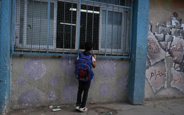 A Palestinian student looks into his classroom while he attends the first day of the new academic year at a UN-run school in Nuseirat, central Gaza Strip, September 19, 2026. (AP Photo/Jehad Alshrafi)