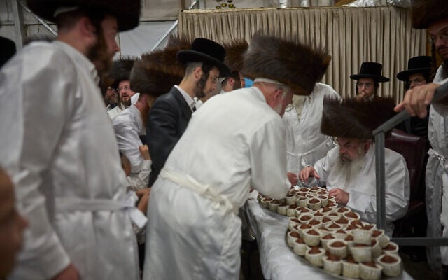 Ultra-Orthodox Jewish men receive cakes from their rabbi ahead of Yom Kippur, which begins at sunset, in Beit Shemesh, September 20, 2026. (AP Photo/Ohad Zwigenberg)