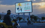 People ride their motorbikes under a billboard showing Houthi leader Abdul Malik al-Houthi with a phrase that reads, in Arabic; “master of words and deeds,” in Sanaa, Yemen, September 21, 2026. (AP Photo/Osamah Abdulrahman)