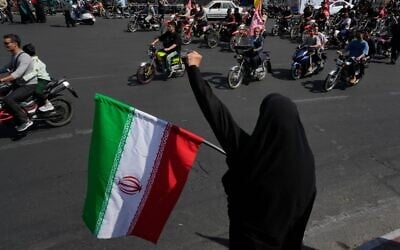 A woman chants slogan as she holds an Iranian flag while motorcyclists ride during a state-organized motorcycle parade called 'Janfada,' meaning 'Sacrifice for Iran,' in Tehran, Iran, September 25, 2026. (AP Photo/Vahid Salemi) A woman chants slogan as she holds an Iranian flag while motorcyclists ride during a state-organized motorcycle parade called 'Janfada,' meaning 'Sacrifice for Iran,' in Tehran, Iran, September 25, 2026. (AP Photo/Vahid Salemi)