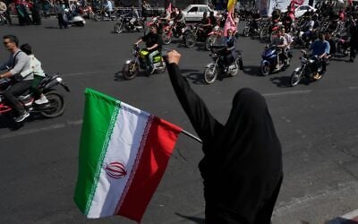 A woman chants slogan as she holds an Iranian flag while motorcyclists ride during a state-organized motorcycle parade called 'Janfada,' meaning 'Sacrifice for Iran,' in Tehran, Iran, September 25, 2026. (AP Photo/Vahid Salemi) A woman chants slogan as she holds an Iranian flag while motorcyclists ride during a state-organized motorcycle parade called 'Janfada,' meaning 'Sacrifice for Iran,' in Tehran, Iran, September 25, 2026. (AP Photo/Vahid Salemi)
