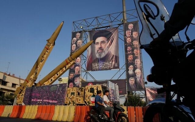 Motorbikes drive past Iranian missiles and banners showing portraits of the Iranian Supreme Leader Ayatollah Mojtaba Khamenei, center, and the late armed forces commanders and nuclear scientists, who were killed in Israeli and US strikes, at Baharestan Square, in Tehran, September 28, 2026. (AP/Vahid Salemi)