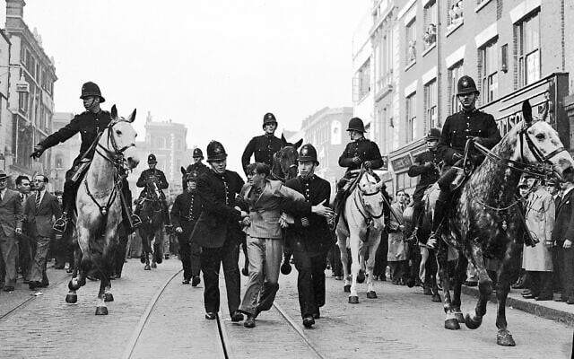 A demonstrator is taken away under arrest by police officers after a mounted baton charge, in East London, on October 4, 1936, to stop fighting between anti-fascists and Sir Oswald Mosley’s Blackshirts. (AP Photo/Worth)