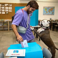 A man casts his vote with his dog at a voting station in Tel Aviv, during the Knesset Elections, on November 1, 2022. (Gideon Markowicz/Flash90)