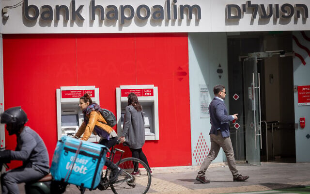 A woman takes out money from a Bank Hapoalim ATM in Tel Aviv on March 25, 2025. (Miriam Alster/FLASH90) A woman takes out money from a Bank Hapoalim ATM in Tel Aviv on March 25, 2025. (Miriam Alster/FLASH90)