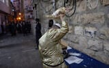 Ultra-Orthodox Jews perform the Kapparot ceremony in the ultra orthodox Jewish neighborhood of Meah Shearim, Jerusalem, on September 30, 2025. (Chaim Goldberg/Flash90)