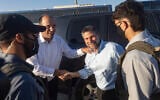MK Simcha Rothman (left) and Finance Minister Bezalel Smotrich (right), flanked by masked security personnel, arrive at a ceremony marking the establishment of the new Israeli settlement of Ma’ale Arugot in Gush Etzion, in the West Bank, September 2, 2026. (Chaim Goldberg/Flash90)