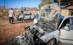 Palestinians inspect burned-out cars after an attack by settlers, where they also spray-painted Hebrew graffiti on the walls of a house in Beita, south of Nablus in the West Bank, September 2, 2026. (Nasser Ishtayeh/Flash90)