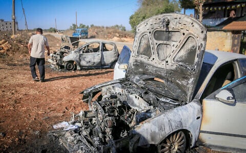 Palestinians inspect burned-out cars after an attack by settlers, where they also spray-painted Hebrew graffiti on the walls of a house in Beita, south of Nablus in the West Bank, September 2, 2026. (Nasser Ishtayeh/Flash90)