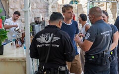 Adir Schwartz talks with Jerusalem municipality inspectors as they shut down a temporary cafe set up by the Hitorerut movement in central Jerusalem after Cafe Basimta closed following weeks of protests by ultra-Orthodox extremists (Yonatan Sindel/Flash90)