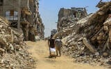 Palestinians walk past destroyed buildings from the recent war in the Tel al-Hawa neighborhood of Gaza City, September 8, 2026. (Abed Rahim Khatib/Flash90)