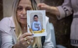 Family members of seven-year-old Hillel Mordechai Dadon, who was allegedly murdered by his neighbor, 26-year-old Liel Ifergan, hold up his picture as prosecutors filed murder charges at the Jerusalem District Court, September 14, 2026. (Yonatan Sindel/Flash90)