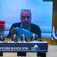 Balad chair Sami Abou Shahdeh appears on a screen behind the Central Elections Committee during a disqualification hearing at the Knesset in Jerusalem, September 23, 2026. (Yonatan Sindel/Flash90)