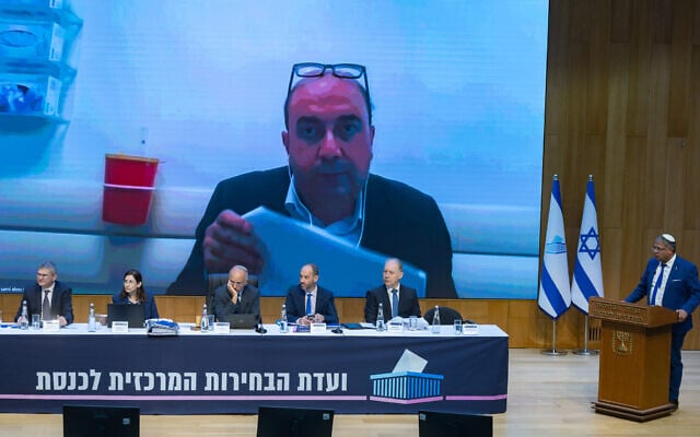 Balad chair Sami Abou Shahdeh appears on a screen behind the Central Elections Committee during a disqualification hearing at the Knesset in Jerusalem, September 23, 2026. (Yonatan Sindel/Flash90)