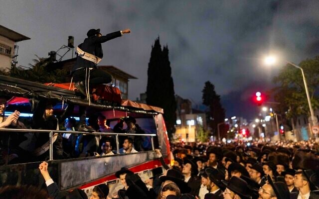 Ultra-Orthodox Jews take part in a procession celebrating draft dodgers following their release from military prison, in Jerusalem on September 29, 2026. (Chaim Goldberg/Flash90)