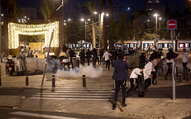 Jewish youths run as a stun grenade explodes near the Damascus Gate outside Jerusalem's Old City after a group attacked Arab men walking through the area, on September 29, 2026. (Chaim Goldberg/Flash90)