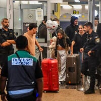 Passengers from flydubai flight FZ1073 walk with their family members through the arrivals hall at Ben Gurion International Airport near Tel Aviv, after their original flight from Dubai to Israel was diverted to Saudi Arabia following an attack on the pilot by his copilot, September 30, 2026. (Avshalom Sassoni/Flash90)
