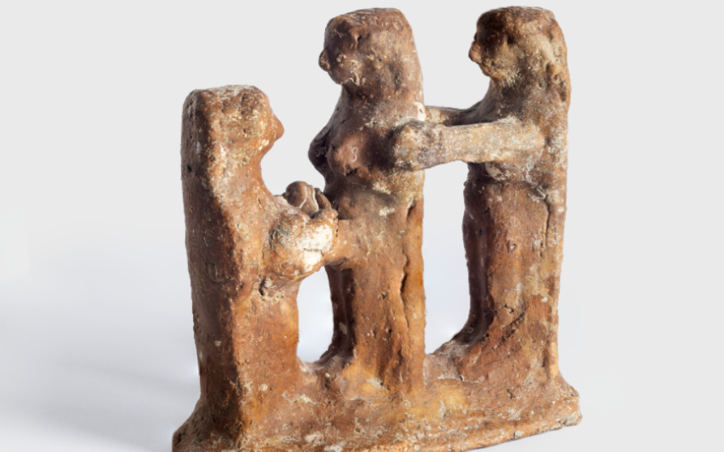 A figurine depicting a woman giving birth, with a midwife in front receiving the infant and a woman behind supporting her (Zohar Shemesh/Israel Museum)