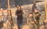 IDF soldiers are filmed praying with settlers at an illegal outpost used to lay siege to Palestinians in the village of Qusra on. August 10, 2026. (Screen capture/X)