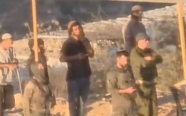 IDF soldiers are filmed praying with settlers at an illegal outpost used to lay siege to Palestinians in the village of Qusra on. August 10, 2026. (Screen capture/X)