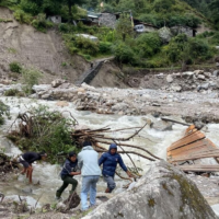 Nepali men stand amid the damage caused by landslides and flooding in the mountain village of Samagaun, where dozens of Israeli tourists were trapped, September 27, 2026. (Courtesy of Passportcard)