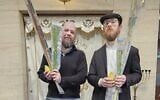 Daniel Rosenbaum, left, and Rabbi Elchanan Kuperman hold sets of the Four Species in front of the synagogue ark at the Wellington Jewish Community Center, in Wellington, New Zealand, September 22, 2026. (Courtesy of Daniel Rosenbaum)