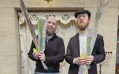 Daniel Rosenbaum, left, and Rabbi Elchanan Kuperman hold sets of the Four Species in front of the synagogue ark at the Wellington Jewish Community Center, in Wellington, New Zealand, September 22, 2026. (Courtesy of Daniel Rosenbaum)