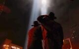 File: Two Jewish men look up as the two columns of light, known as the ‘Tribute in Light’ memorial, shine from lower Manhattan on September 11, 2007, in New York City. (Chris Hondros/Getty Images via JTA)