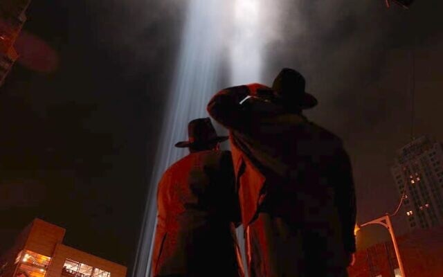 File: Two Jewish men look up as the two columns of light, known as the ‘Tribute in Light’ memorial, shine from lower Manhattan on September 11, 2007, in New York City. (Chris Hondros/Getty Images via JTA)