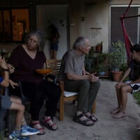 Aviva Siegel, 65, and her husband Keith Siegel, 67, both former hostages, chat with two of their grandchildren at their home in Kibbutz Gazit, northern Israel, August 6, 2026. (Shir Torem/Reuters)