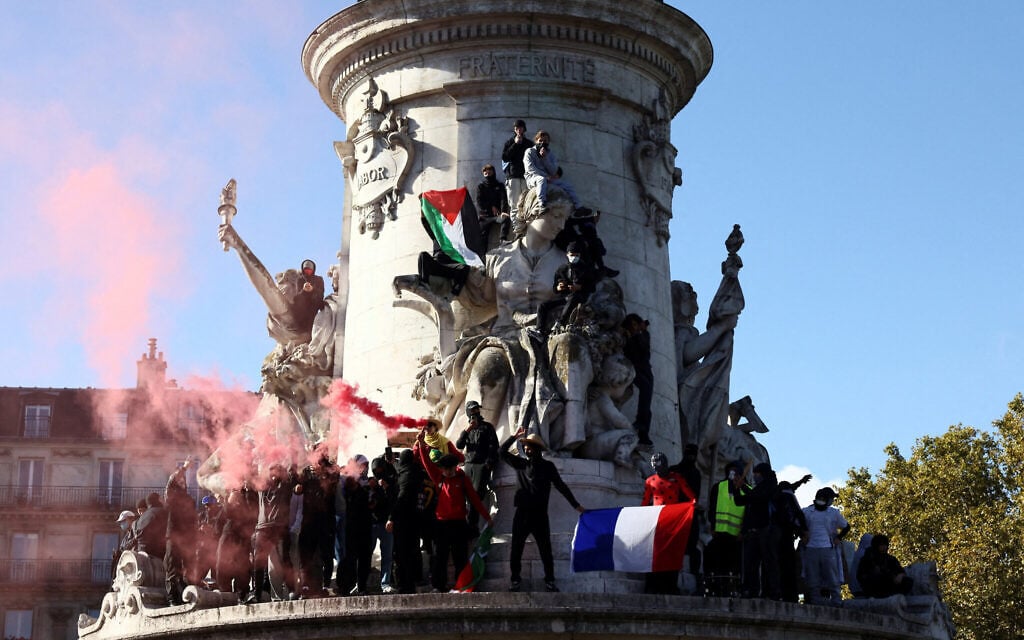 Protesters hold the French flag and the Palestinian flag as they stand on the statue of the Place de la Republique during a demonstration against the cost of living and rising fuel prices in Paris as part of nationwide protests, October 17, 2026. (Jack Taylor/Reuters) Protesters hold the French flag and the Palestinian flag as they stand on the statue of the Place de la Republique during a demonstration against the cost of living and rising fuel prices in Paris as part of nationwide protests, October 17, 2026. (Jack Taylor/Reuters)
