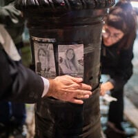 Activists post stickers showing victims of the October 7, 2023, Hamas-led massacre, in New York City, October 6, 2026. (Luke Tress/Times of Israel)