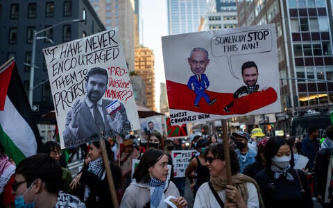 Anti-Zionist protesters hold signs against New York City Mayor Zohran Mamdani, in New York City, October 7, 2026. (Luke Tress/Times of Israel)