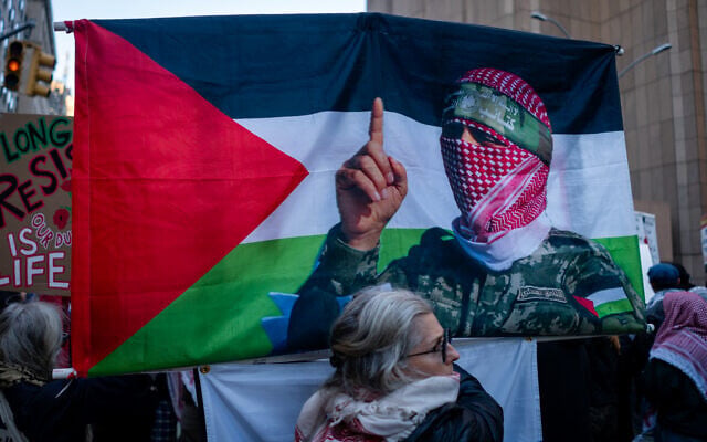 A woman holds a Hamas flag during a protest in New York City, October 7, 2026. (Luke Tress/Times of Israel)