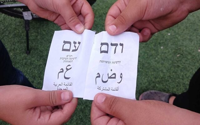 Boys hold dual Arabic- and Hebrew-language ballots of Ra'am and the Joint List outside a polling station in Qalansawe, October 27, 2026. (Noam Lehmann/Times of Israel) Boys hold dual Arabic- and Hebrew-language ballots of Ra'am and the Joint List outside a polling station in Qalansawe, October 27, 2026. (Noam Lehmann/Times of Israel)