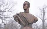 Illustrative: A woman straightens the ribbon on a wreath at the foot of the statue of Ukrainian nationalist leader Roman Shukhevych in the western town of. Bilogorshcha on January 10, 2010. (AFP PHOTO/YURIY DYACHYSHYN)