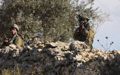 An IDF soldier aims his rifle during a reported attack by settlers on Palestinians picking olives in the village of Beita, south of Nablus, in the West Bank on October 2, 2026. (JAAFAR ASHTIYEH/AFP)