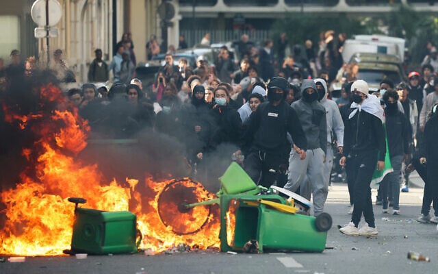 A student puts trashes into a fire as protesting students carry out blockading action near place de la Nation, in Paris, on October 2, 2026. (Thomas SAMSON/AFP) A student puts trashes into a fire as protesting students carry out blockading action near place de la Nation, in Paris, on October 2, 2026. (Thomas SAMSON/AFP)