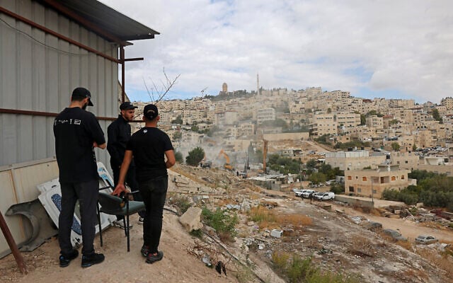 Residents watch as Israeli forces demolish a residential building in the A-Tur neighborhood of Jerusalem, on October 6, 2026. (AHMAD GHARABLI/AFP)